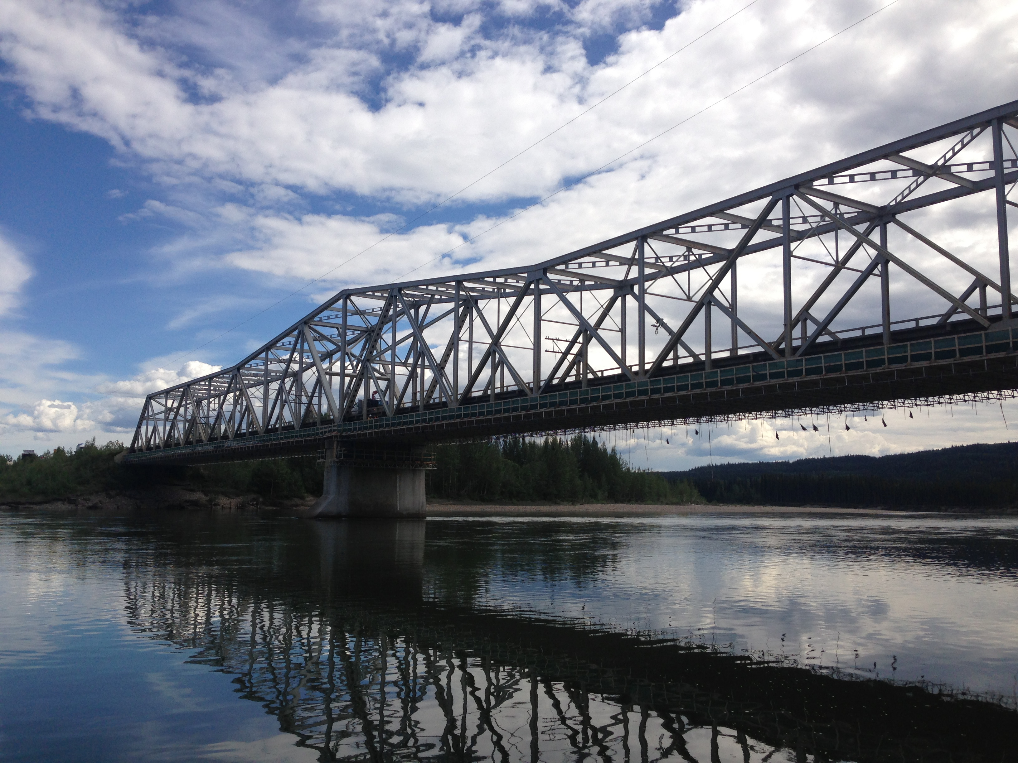 Alaska Highway Bridge retrofit project on a calm day with under deck work platform and environment habitat shield showing!